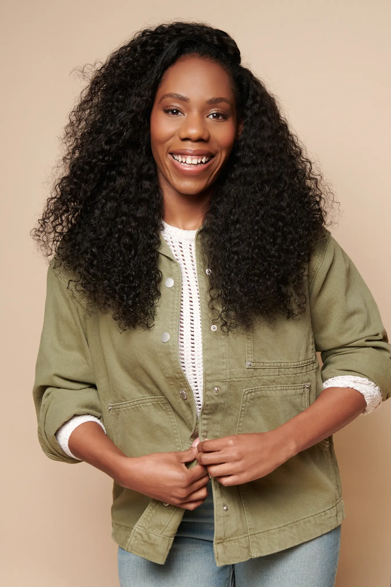 Alesha, the forward-facing smiling founder of Mom Mogul in a green jacket
